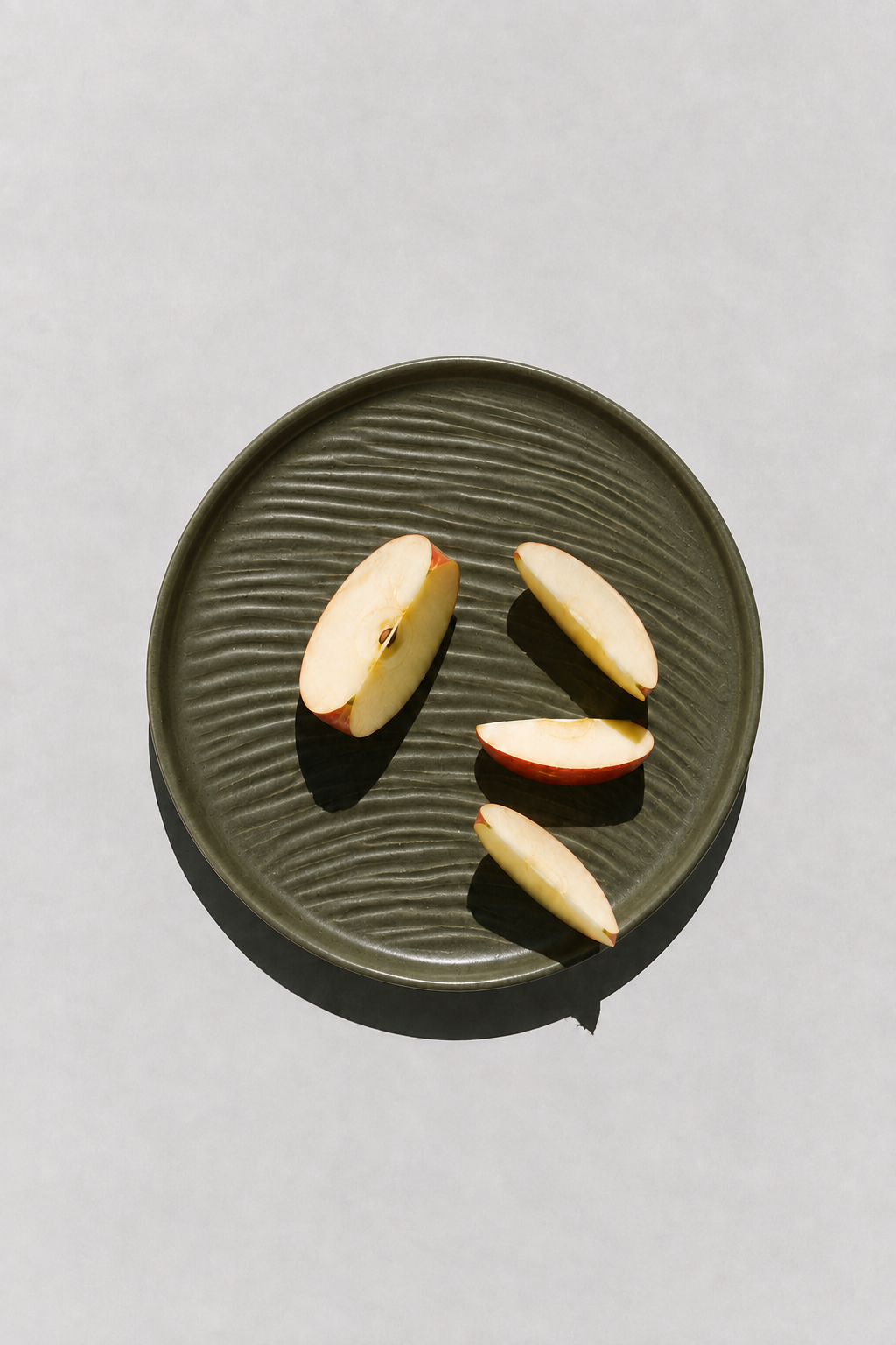 Deep Olive textured stoneware ceramic plate with sliced apple