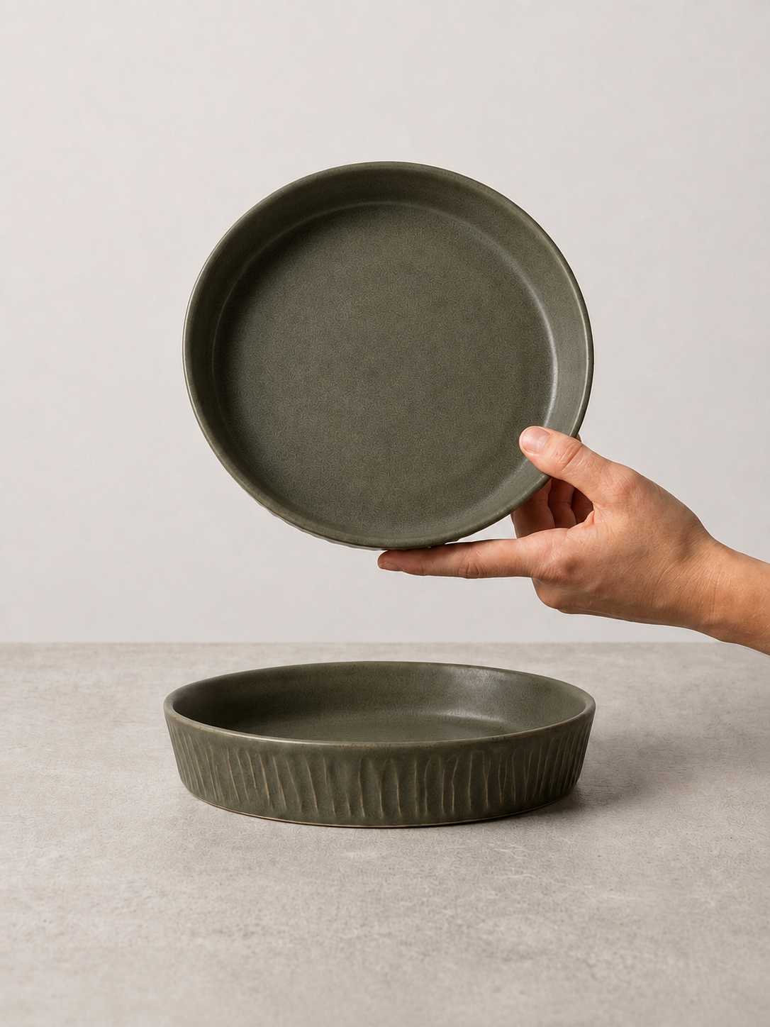 Deep Olive stoneware salad/pasta plate held in hand above a matching plate