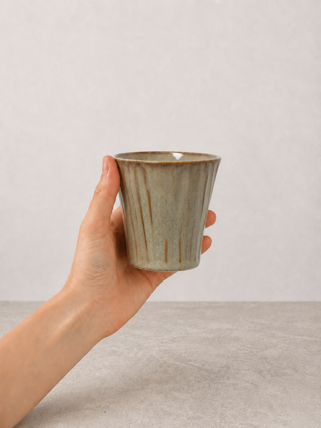 Sage Taupe stoneware mug held in hand against a neutral background