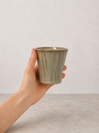 Sage Taupe stoneware mug held in hand against a neutral background