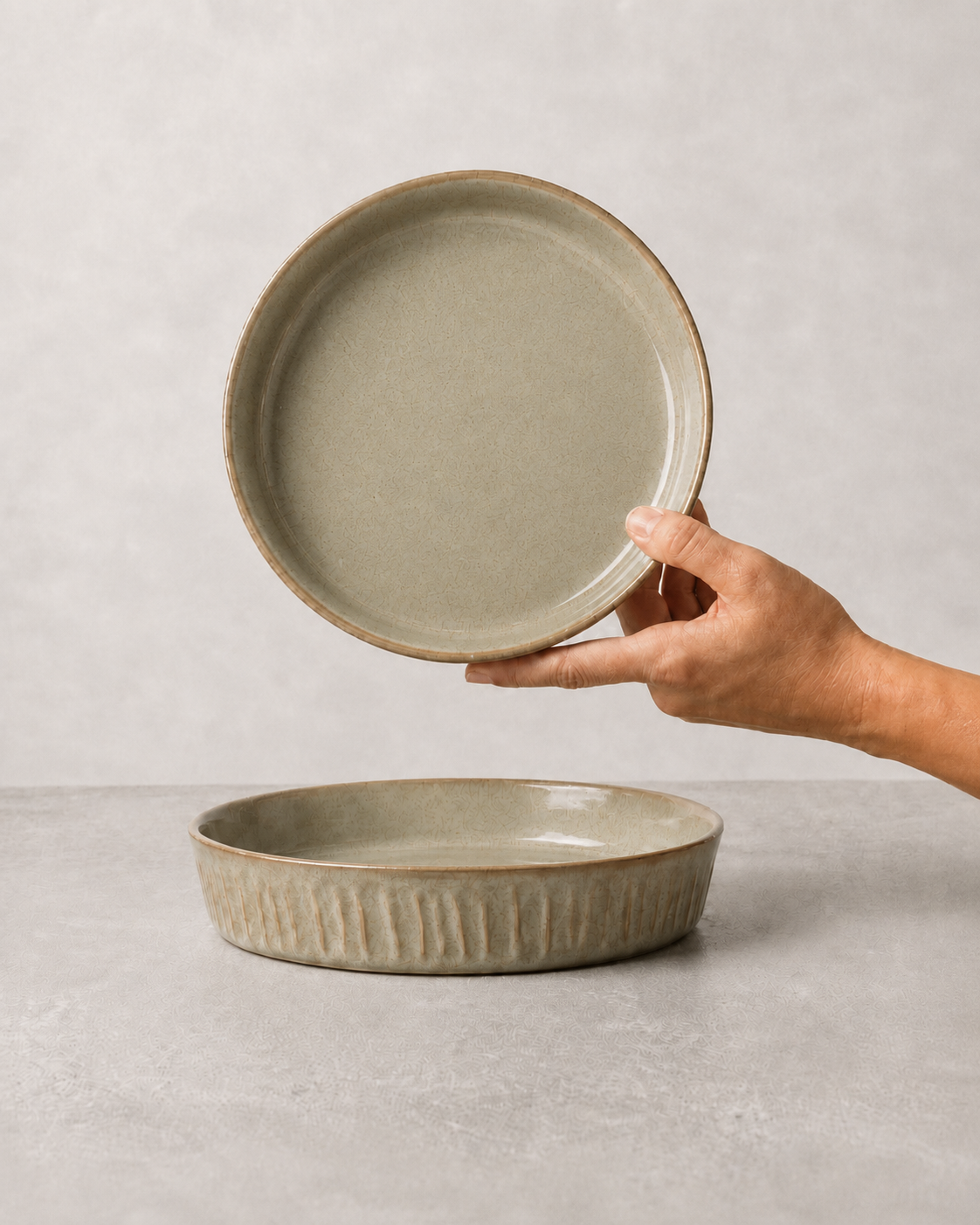 Sage Taupe stoneware salad/pasta plate held in hand above a matching plate